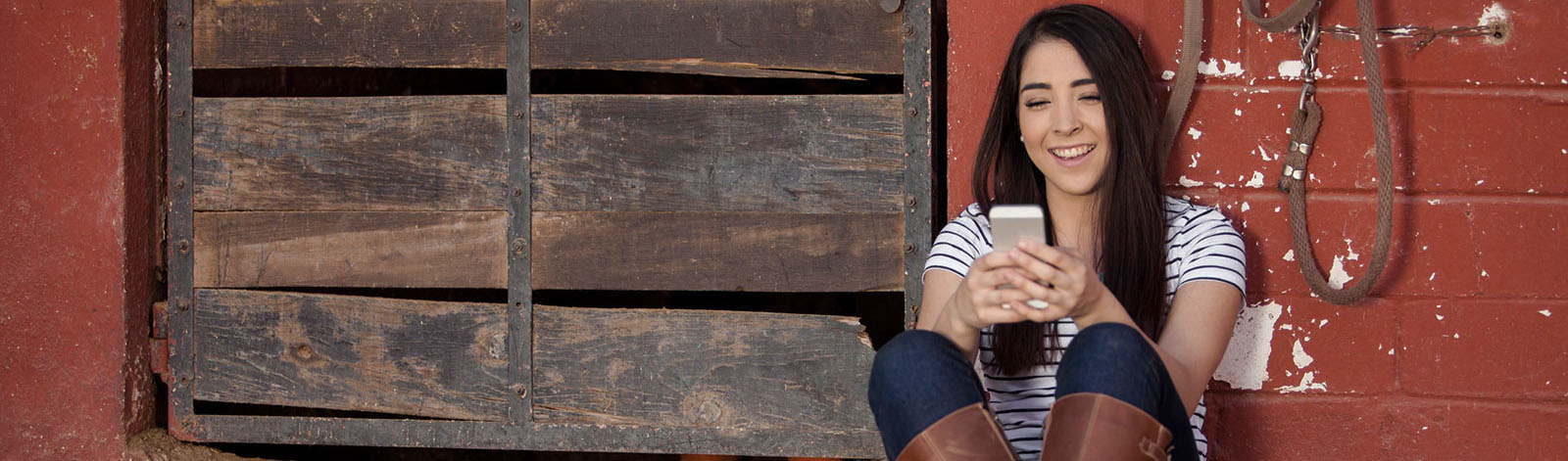 Girl on phone at barn