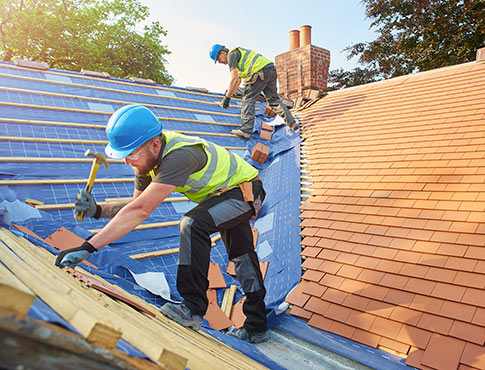 Construction workers roofing a house