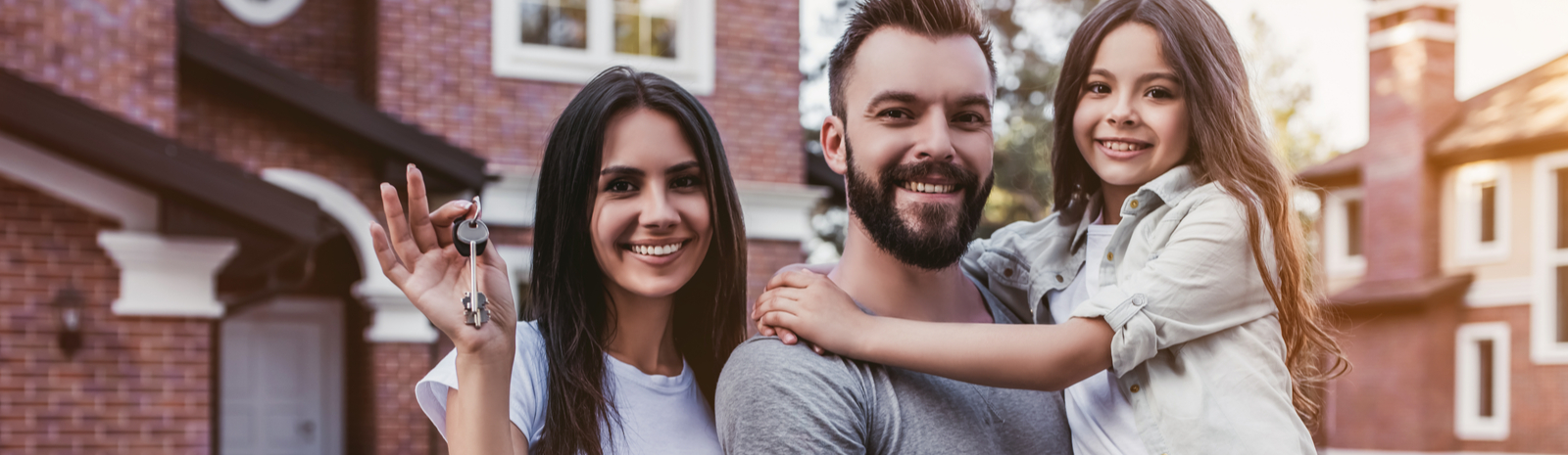 family in front of new home with keys