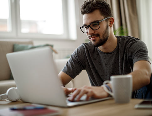 A man using a laptop computer  in his home