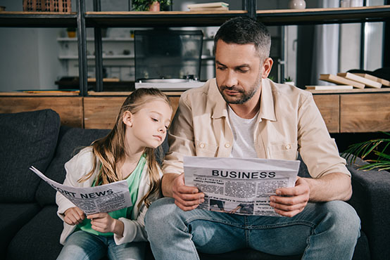 Father and daughter reading the paper