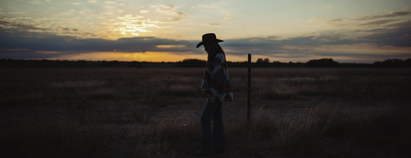 young girl on ranch at sunset